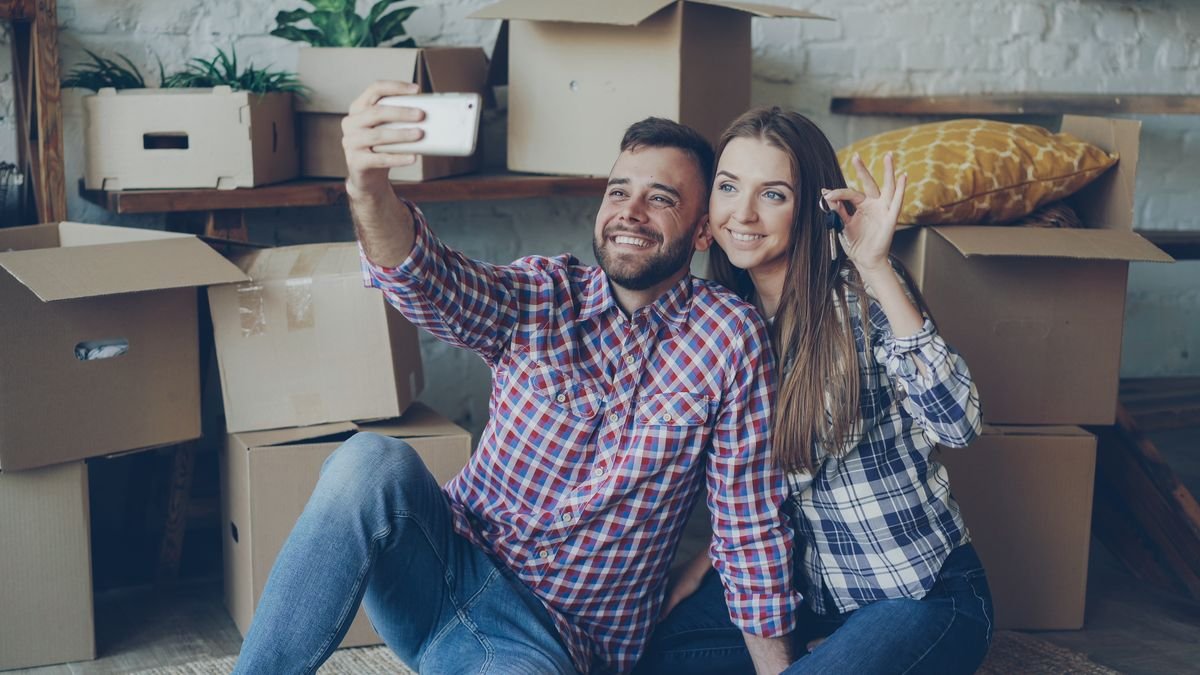 Glückliches Paar macht ein Selfie in der neuen Wohnung – finanzieren Sie Ihr Zuhause